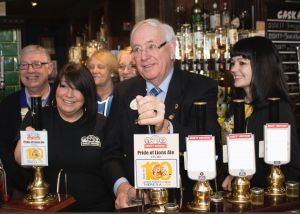 District Governor David McDowell pulls the first pint of the Centenniel Ale